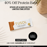 Promotional graphic for Tusol Caramel + Sea Salt protein bars, showing one wrapped bar on a light cream background with sale text, a black 'As seen in Forbes' badge, and caramel pieces as props.